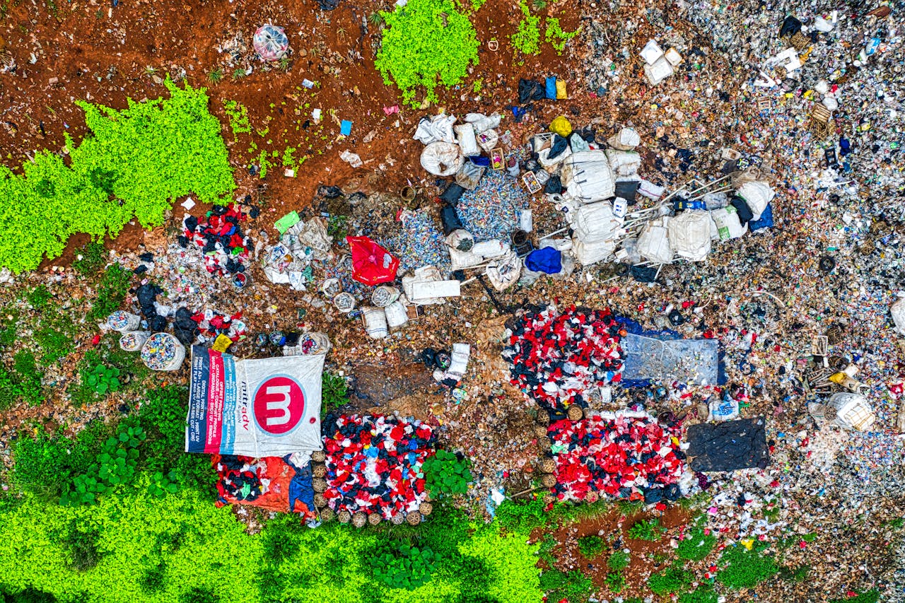An aerial shot showing piles of waste in a dumpsite surrounded by greenery in Banten, Indonesia.